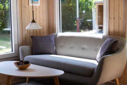 Udestuen vender ud mod haven med lyst træloft og store vinduer.